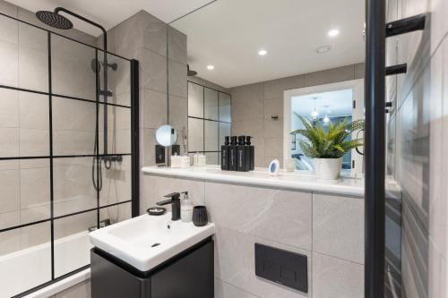 a bathroom with a sink and a shower at 2 Bed Apartment, in the heart of Manchester City Centre! 7 mins walk from Piccadilly Station! in Manchester