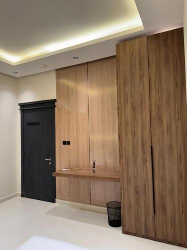 a bathroom with wooden cabinets and a black door at Luxury 2BR - Steps To Boulevard in Riyadh