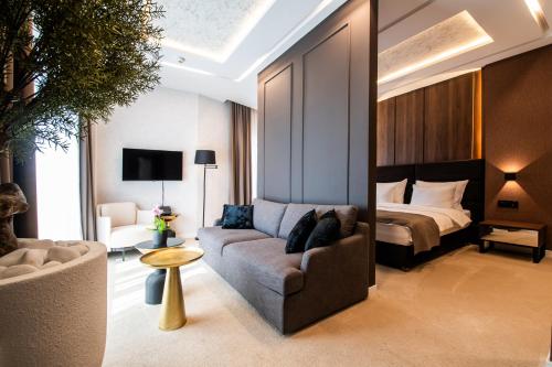 a living room with a couch and a bed at Premium Hotel, Novi Sad in Novi Sad