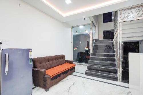 a living room with a couch and a refrigerator at Hotel O The Skyrise Lucknow Hotel in Kākori