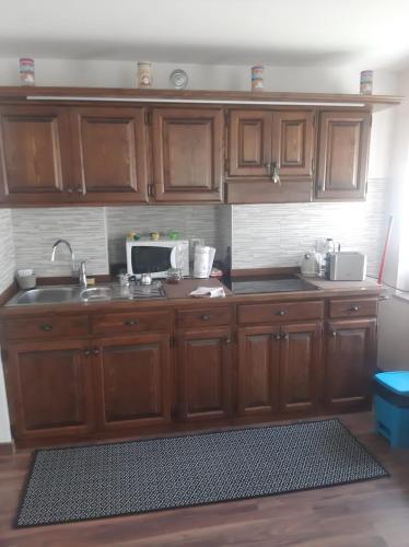 a kitchen with wooden cabinets and a microwave at CA' VIRASOLELH in Macra