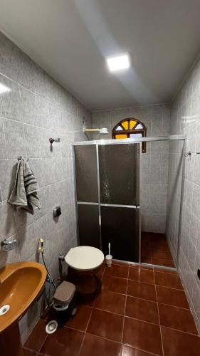 a bathroom with a shower and a sink and a toilet at Casa sossego do mar Praia Guriri - São Mateus ES in São Mateus