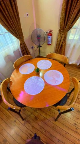 a wooden table with chairs and a wooden floor at Rapid Roost Apartments in Umuahia
