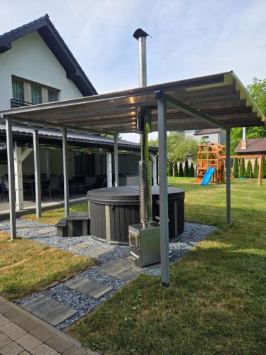 a pergola with a grill in a yard at ZuMiLu House in Zagórz