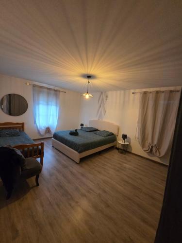 a large bedroom with two beds and a ceiling at Maison du bonheur in Montier-en-Der