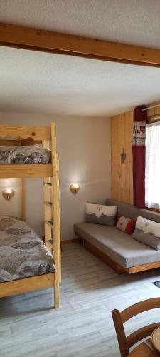 a bedroom with two bunk beds and a couch at Appartement à Montchavin in La Plagne Tarentaise