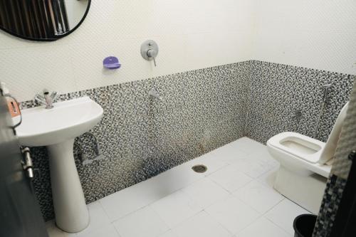 a bathroom with a sink and a toilet at Yogi Resort And Garden Cafe in Rishīkesh