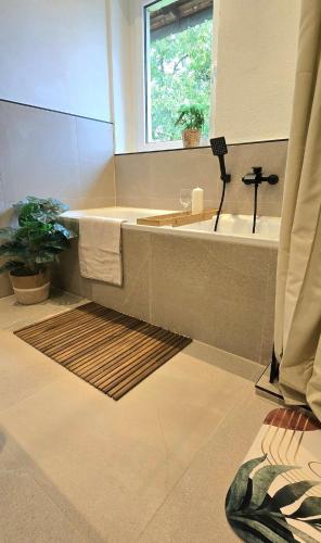 a bathroom with a tub and a sink and a window at FeWo Oahu in Meisenheim