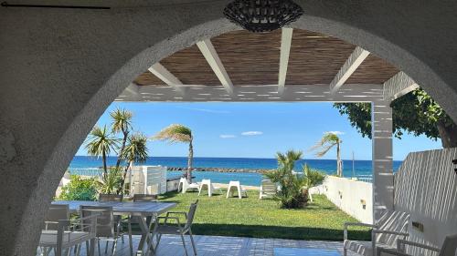 ベルヴェデーレ・マリッティモにあるVilla a Diamante Sulla Spiaggiaのテーブルと椅子と海のあるパティオ