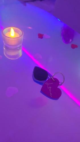 a candle and a pair of flip flops on a table at Love room à 30 mn des plages et de Vannes in Questembert