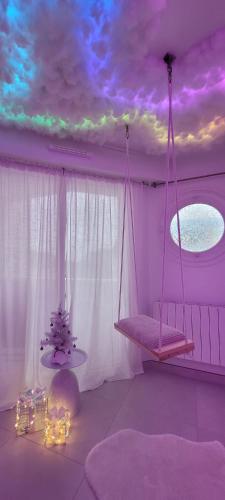 a room with a swing hanging from a ceiling at Love room à 30 mn des plages et de Vannes in Questembert