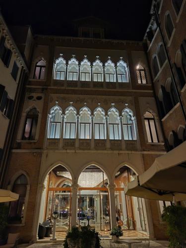 a large building with arches and windows at night at Sina Centurion Palace in Venice