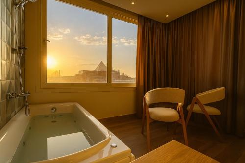カイロにあるNefri Pyramids Hotelの浴槽と椅子と窓のあるバスルーム