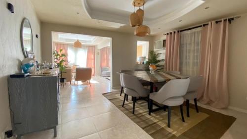a dining room and living room with a table and chairs at hotel apartments cairo downtown in Cairo