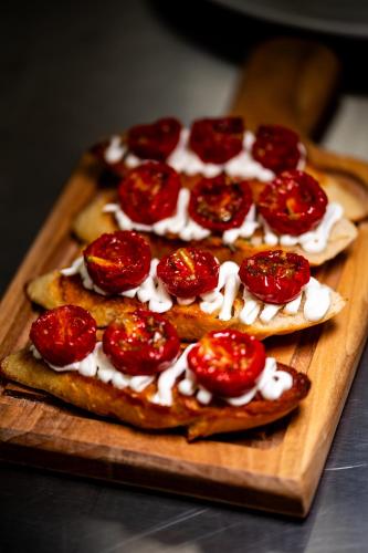 a group of pizzas on a wooden cutting board at Premium Hotel, Novi Sad in Novi Sad