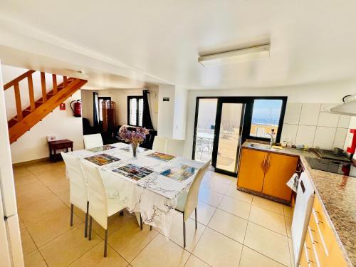 a kitchen and dining room with a table and chairs at Maria Cottage with Sea View in Estreito da Calheta