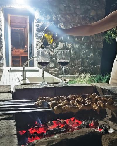 two glasses of wine over a fire grill at Zove Rural Cottage with garden views in Kʼarashamb