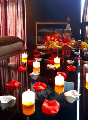 a table with red flowers and candles on it at Viagio hoteL in Yerevan