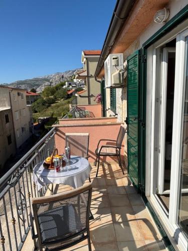 a patio with a table and chairs on a balcony at Nemira IX Vacations in Omiš
