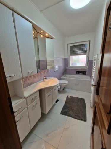a bathroom with a sink and a toilet and a mirror at Ferienwohnung Neuss-Süd in Neuss