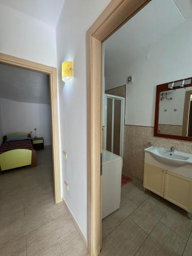 a bathroom with a sink and a tub and a mirror at Holiday Properties Moradias Green - Wi-Fi in Santa Maria