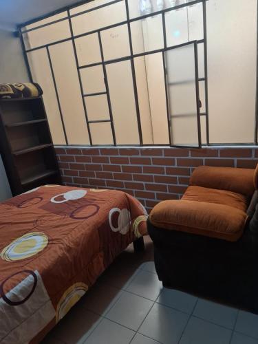 a room with a bed and a chair and a window at Casita entre los cerros in Sucre