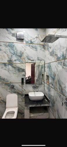 a bathroom with a toilet and a sink at Krishna Cottage in Chauri Chaura