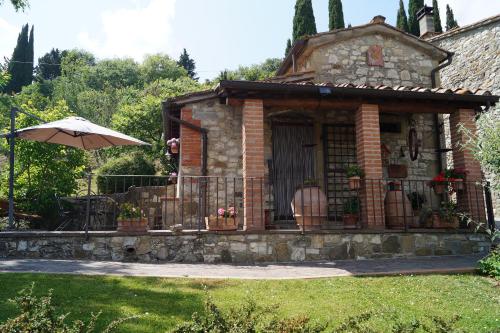 a small house with an umbrella in a yard at Il Borghetto di Carra in Talla