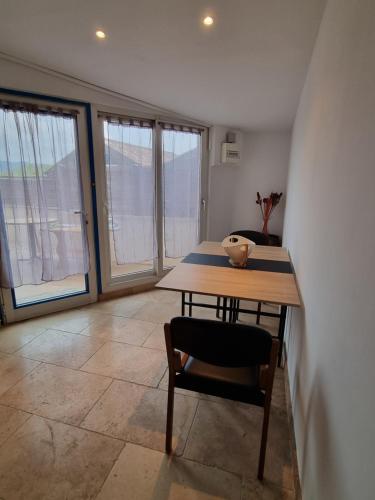 a table and a chair in a room with windows at La Forge in Aubagne