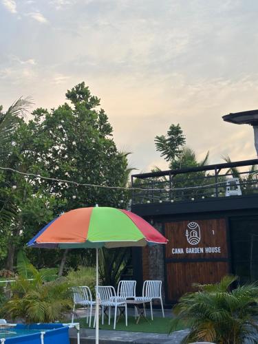 a colorful umbrella sitting in front of a building at Cana Garden House 1 โฮมสเตย์ in Ban Khok