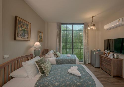 a bedroom with two beds and a window at VANA Homestay in Ban Tai