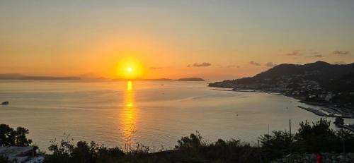a sunset over a body of water with the sun setting at Appartamenti Miramare in Collina in Ischia