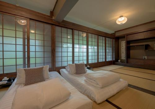 a room with two beds in a room with windows at VANA Homestay in Ban Tai