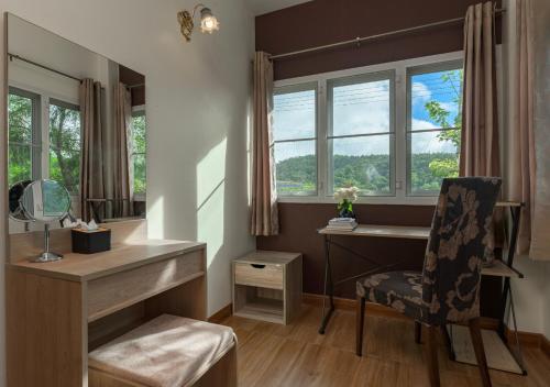 a bathroom with a desk and a chair and a mirror at VANA Homestay in Ban Tai