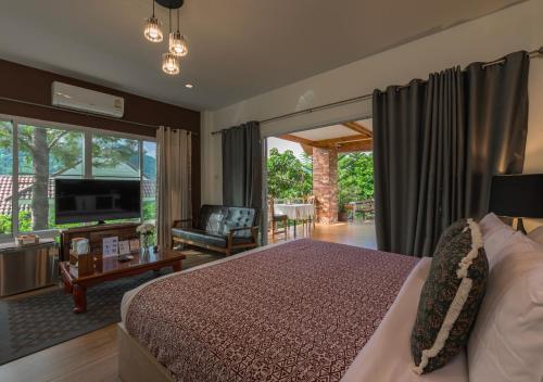a bedroom with a bed and a living room at VANA Homestay in Ban Tai