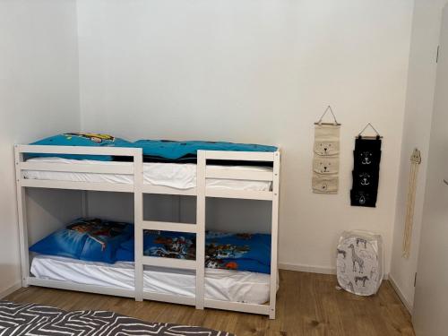 a bedroom with a white bunk bed with blue sheets at Ferien und Monteurwohnung mit Garage im Gäu in Gäufelden
