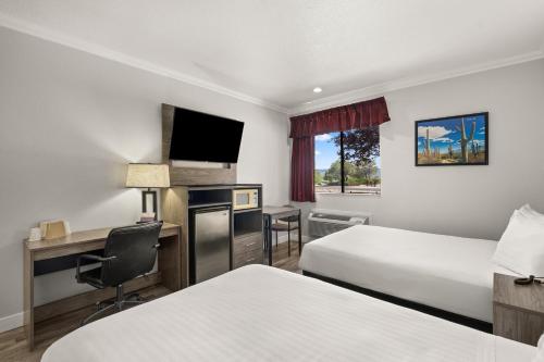 a hotel room with two beds and a desk at Americas Best Value Inn Prescott Valley in Prescott Valley