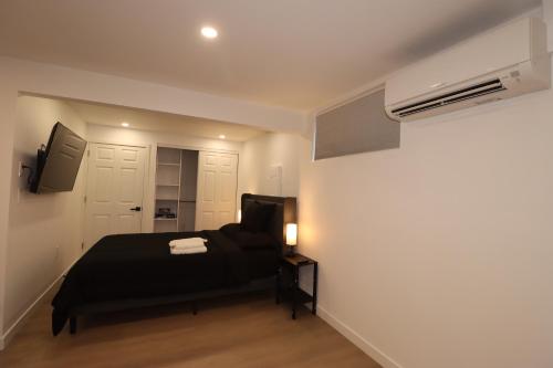 a bedroom with a black bed and a white wall at 2 bedrooms near Downtown, Airport, stadiums, light rail in Seattle