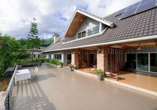 a house with a deck with a roof at VANA Homestay in Ban Tai