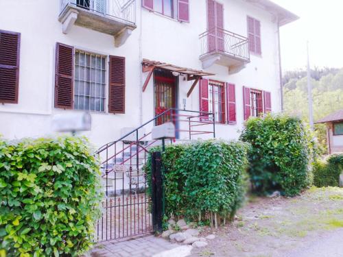 a white house with a gate and bushes at Apartment Narzole LanghExplorer in Narzole
