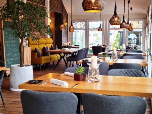 a restaurant with wooden tables and chairs and tablesktop at Komfort-Hotel Katerberg in Lüchow