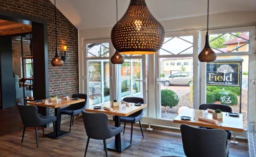 a restaurant with tables and chairs and windows at Komfort-Hotel Katerberg in Lüchow