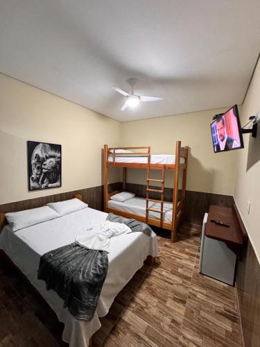 a bedroom with a bunk bed and a ladder at JV Pousada in Paraty