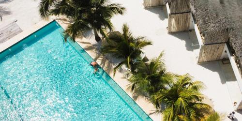 an overhead view of a swimming pool with palm trees at Infinity Beach Boutique Hotel & SPA in Matemwe