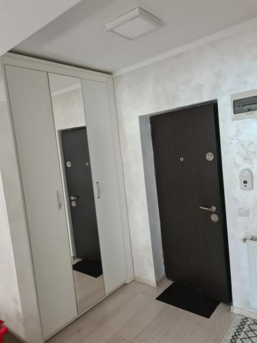 a hallway with two doors and a mirror at Fiald-Apartament Nou in Bacău