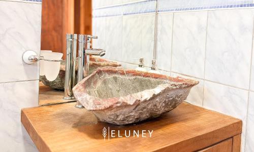 a large stone sink on a wooden counter in a bathroom at ELUNEY Pichilemu in Pichilemu