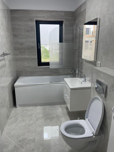 a bathroom with a toilet and a tub and a sink at Apartment in Ploiești 5 in Ploieşti