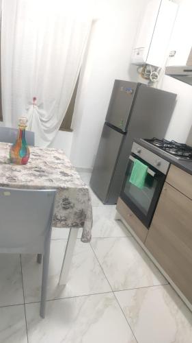 a kitchen with a table and a stove and a table with a chair at Fair Heaven - Modern Stay Near Metro Bisceglie and San Siro in Milan