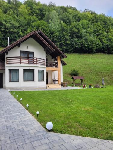 a house with a lawn with golf balls in the yard at Cabana Valea Muntelui in Poiana Mărului
