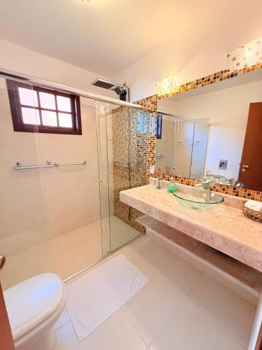 a bathroom with a shower and a toilet and a sink at Gidu Ilhabela in Ilhabela